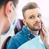 Man with toothache visiting emergency dentist