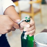 Person using bottle cap opener