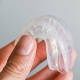 Patient holding clear mouthguard