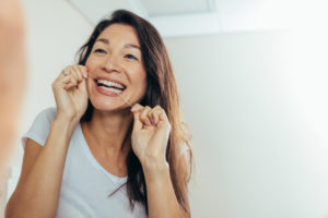 women flossing her teeth