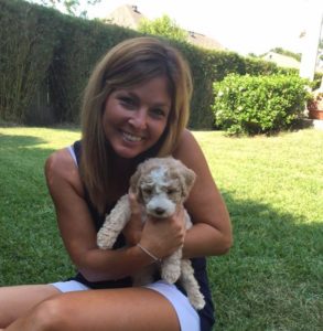 A women holding a puppy in a garden