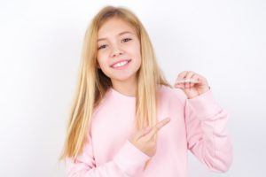 a girl in pink sweatshirt smiling