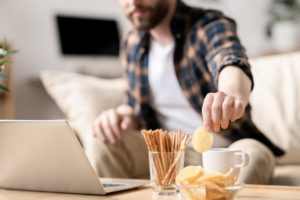 A men watching something and snacking