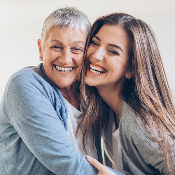 mom and mature daughter smiling together